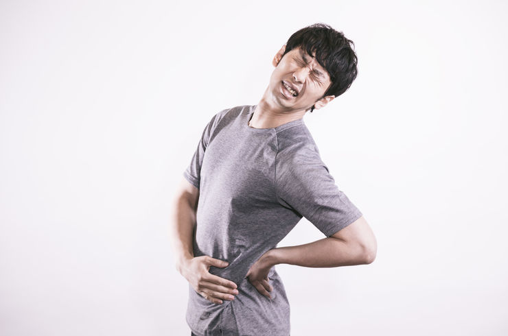 男性が腰を痛そうにしている画像